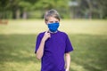 Boy points to his homemade face mask, to demontrate how to properly wear it, during coronavirus pandemic