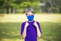 Boy points to his homemade face mask, to demontrate how to properly wear it, during coronavirus pandemic