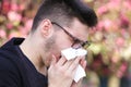 Ill boy with flu is sneezing in the park Royalty Free Stock Photo