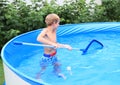 Boy in pool cleaning water Royalty Free Stock Photo