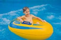 Boy on a pool float on artificial waves in a water park Royalty Free Stock Photo