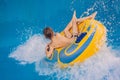 Boy on a pool float on artificial waves in a water park Royalty Free Stock Photo