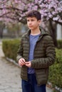 Boy portrait, city outdoor, blooming trees, spring season, flowering time Royalty Free Stock Photo