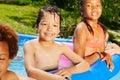 Boy portrait among friends in the swimming pool