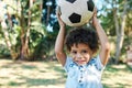 Boy, portrait and soccer ball in garden park for playing games or learning sports, weekend or grass. Kid, happy and face Royalty Free Stock Photo