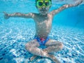 A boy poses for the camera under water in a swimming pool on holiday. Royalty Free Stock Photo