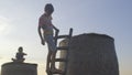 Boy posing with a ladder. Silhouette against the sky.