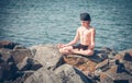 Boy practising yoga on beach Royalty Free Stock Photo