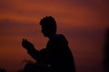 A boy praying in evening time with a beautiful sky in the background