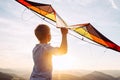 Boy prepare to fly a kite over the mountain hills