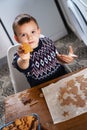 A boy prepares gingerbread cookies in the kitchen. Christmas family traditions. Leisure of the child during the New Royalty Free Stock Photo