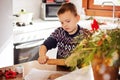 A boy prepares gingerbread cookies in the kitchen. Christmas family traditions. Leisure of the child during the New Royalty Free Stock Photo