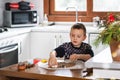 A boy prepares gingerbread cookies in the kitchen. Christmas family traditions. Leisure of the child during the New Royalty Free Stock Photo