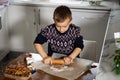 A boy prepares gingerbread cookies in the kitchen. Christmas family traditions. Leisure of the child during the New Royalty Free Stock Photo