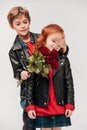 boy presenting roses bouquet to his little girlfriend and covering her eyes with hand