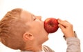 Boy in profile bites a whole red apple Royalty Free Stock Photo