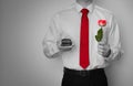 Nervous man getting ready to propose to his girlfriend, surprising her wearing a dress shirt and red tie, holding a ring box Royalty Free Stock Photo