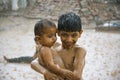 A boy protecting his little brother from heavy rain