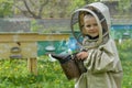 The boy in protective clothing beekeeper works on an apiary. Apiculture. Royalty Free Stock Photo