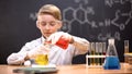 Boy in protective glasses mixing chemical liquids in flasks, curious genius Royalty Free Stock Photo