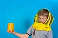 A boy in a protective mask from bees holds in his hand a jar of honey on a blue background Royalty Free Stock Photo