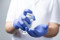 Boy with protective mask and blue gloves washing yours hands with alcohol during coronavirus quarantine