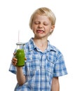 Boy pulling face holding green smoothie Royalty Free Stock Photo