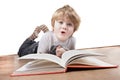 Boy pulling a funny face whilst reading book Royalty Free Stock Photo