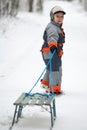 The boy is pulling old sledges