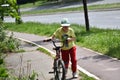 The boy pushes the bike along the bike path