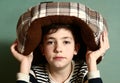 Boy put cat bed as a hat on his head