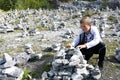 Boy puts stones in heap in marble canyon Royalty Free Stock Photo