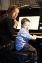 Boy putting index finger on lips with his piano