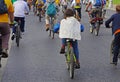 A boy in a raincoat with a drawing of a bicycle takes part in bike parade