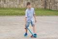 Boy raises sport board with his legs on stone pavement