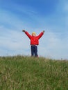 The boy is raising his hands against the blue sky Royalty Free Stock Photo