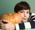 Boy with raw whole pumpkin for halloween