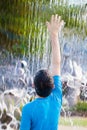 Boy reaching up to feel water in a waterfall Royalty Free Stock Photo