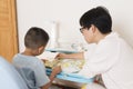 Boy reading aloud with tutorship