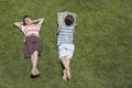 Boy Reading Besides Asleep Brother On Grass Royalty Free Stock Photo