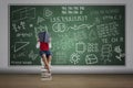 Boy reading book in class sitting on stack of books Royalty Free Stock Photo