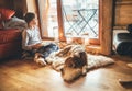 Boy reading book on the floor near slipping his beagle dog on sheepskin in cozy home atmosphere. Peaceful moments of cozy home