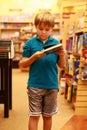 Boy reading book at library or book store Royalty Free Stock Photo