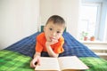 Boy reading book lying on bed,children education, child portrait with book, education concept, interesting story book Royalty Free Stock Photo