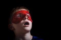 Boy in red carnival mask on black background. Portrait closeup isolated Royalty Free Stock Photo