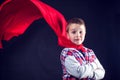 A boy with red cloak like a superhero. Children and success concept