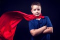 A boy with red cloak like a superhero. Children and success concept