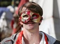 Boy in a red and gold mask, a costume performance at a medieval fair, community event