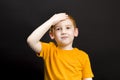 a boy with red hair holding his head Royalty Free Stock Photo