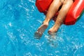 Boy in the red inflatable mattress in pool